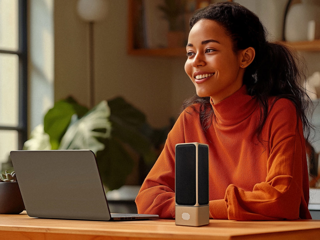 Mulher sorridente usando um notebook com microfones SOVA R1 preto e creme