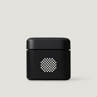 Black compact audio amplifier on a neutral background